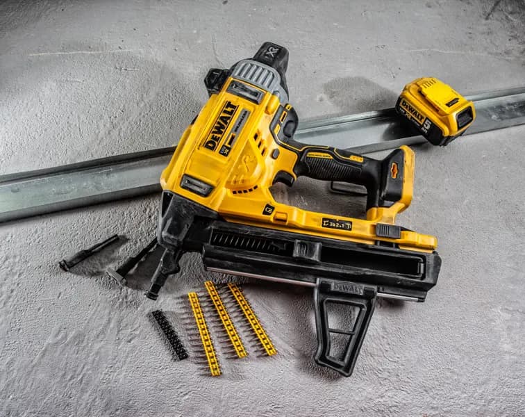 Cloueur à batterie DEWALT DCN890P2 avec accessoires et fixations sur surface béton.